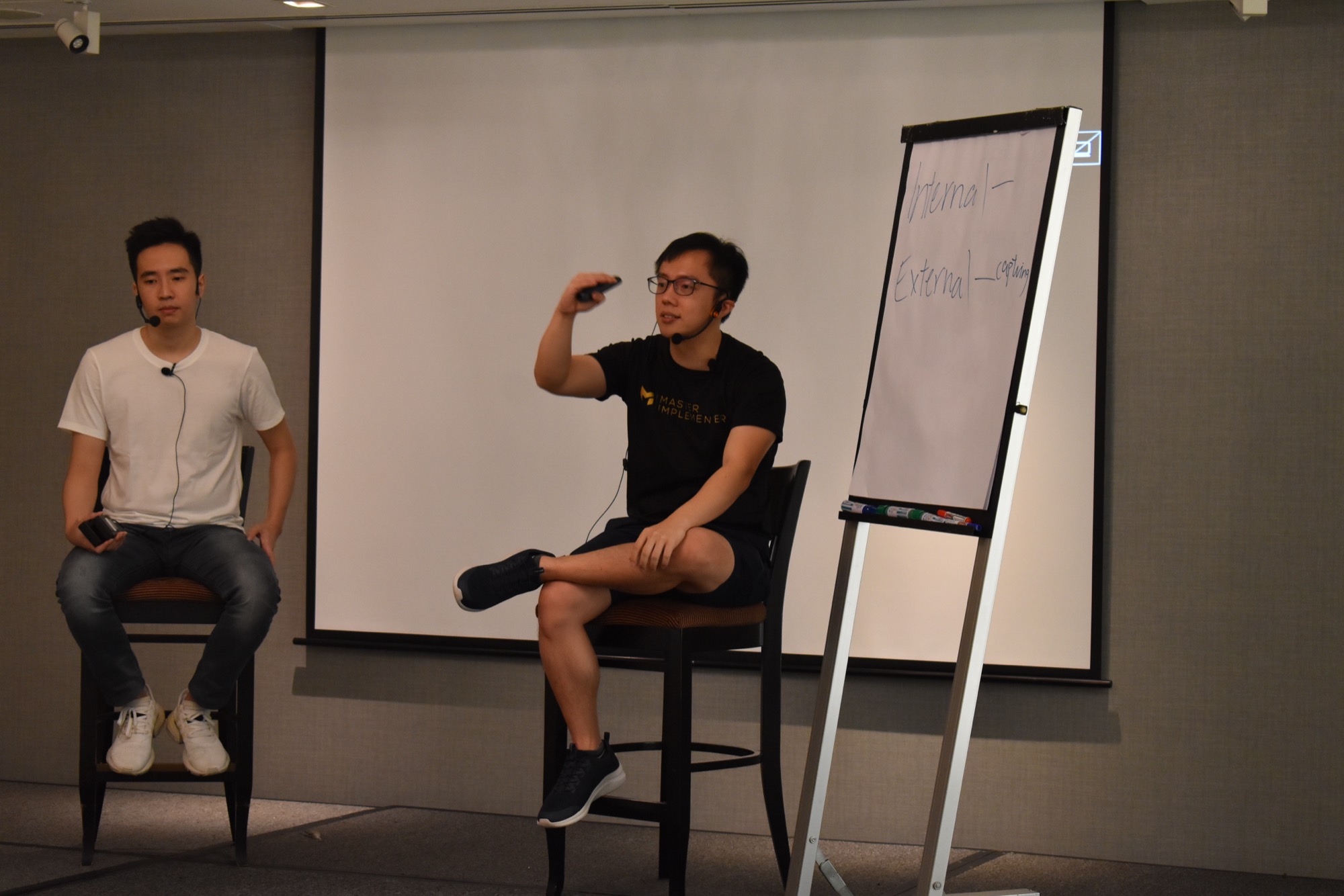Marc Teo teaching at a flip chart, arms open.